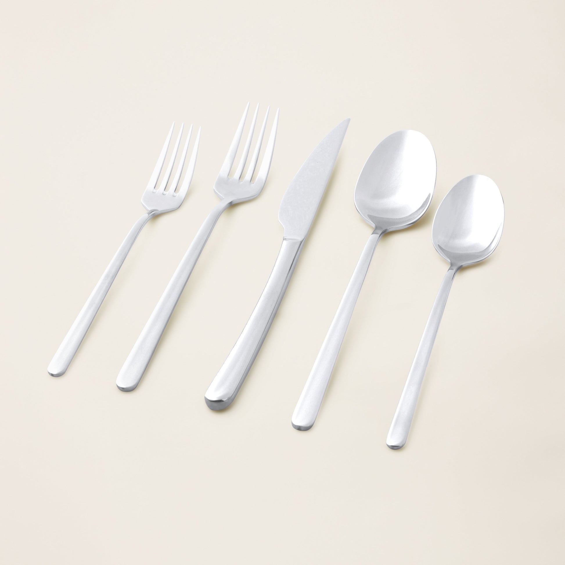 Silver flatware set with forks, knives, and spoons laid out