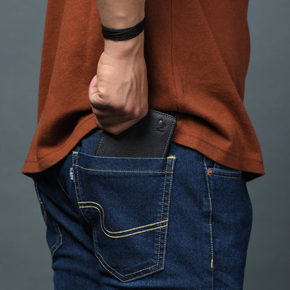 Black leather wallet held in hand with a compact bifold profile