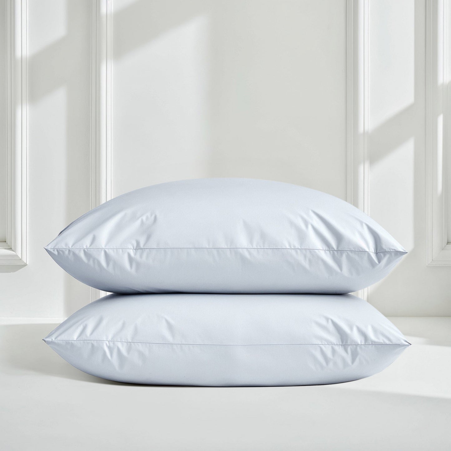 Sateen sheet set in pale blue with two pillows stacked on bed