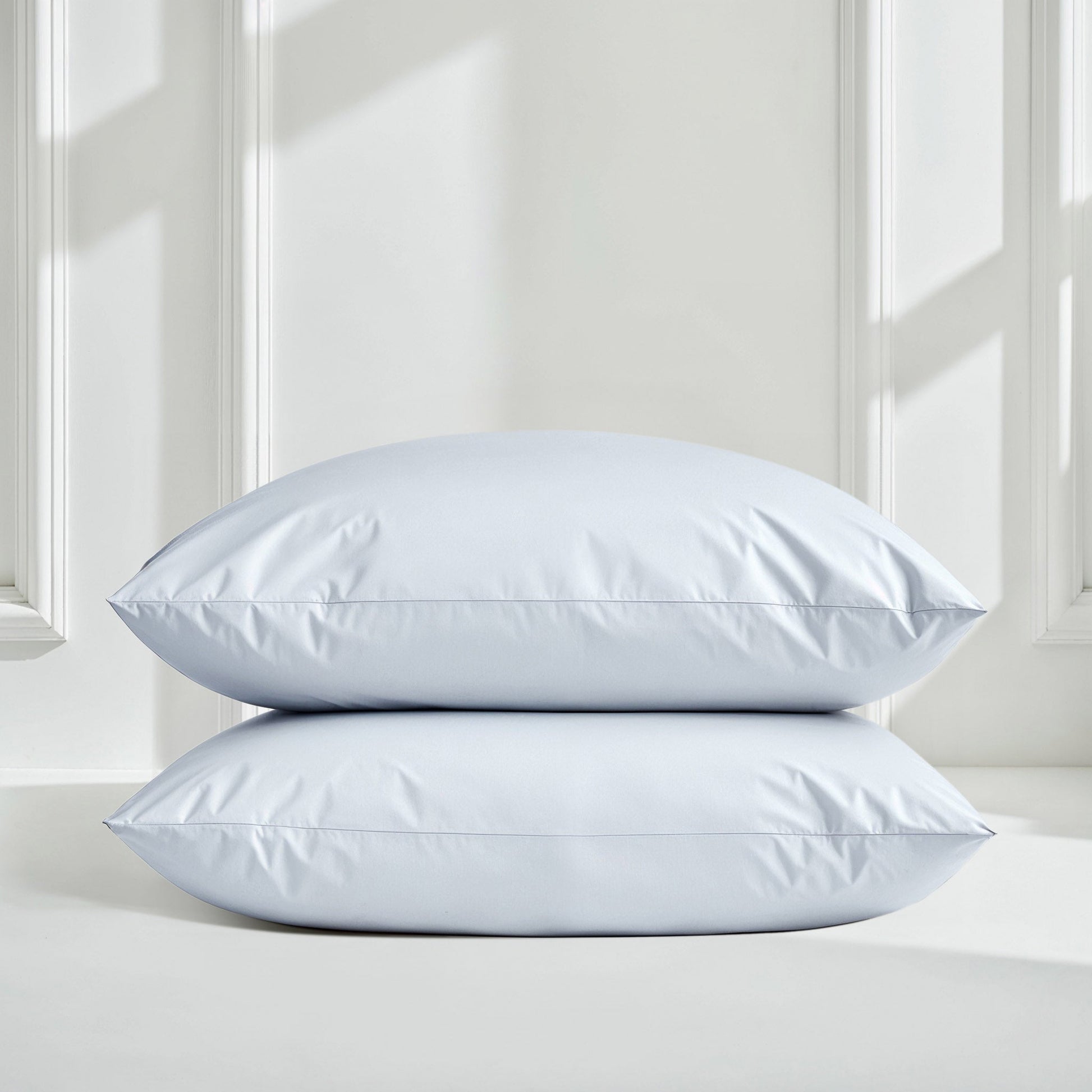 Sateen sheet set in pale blue with two pillows stacked on bed