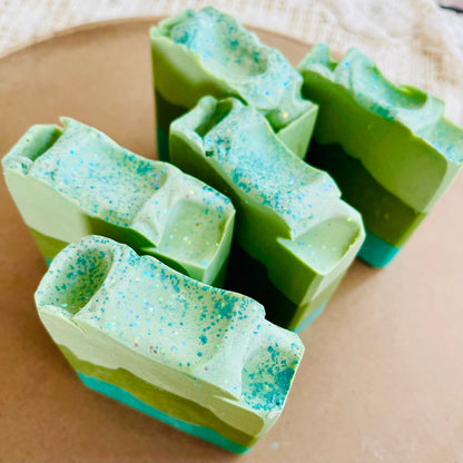 Cut mint and teal soap bars with speckled texture, stacked in pieces