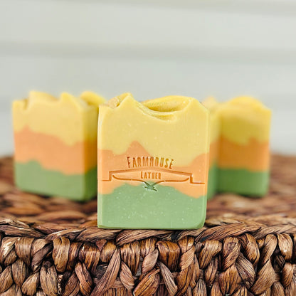 Three-layer soap bars in yellow, orange, and green with brand label