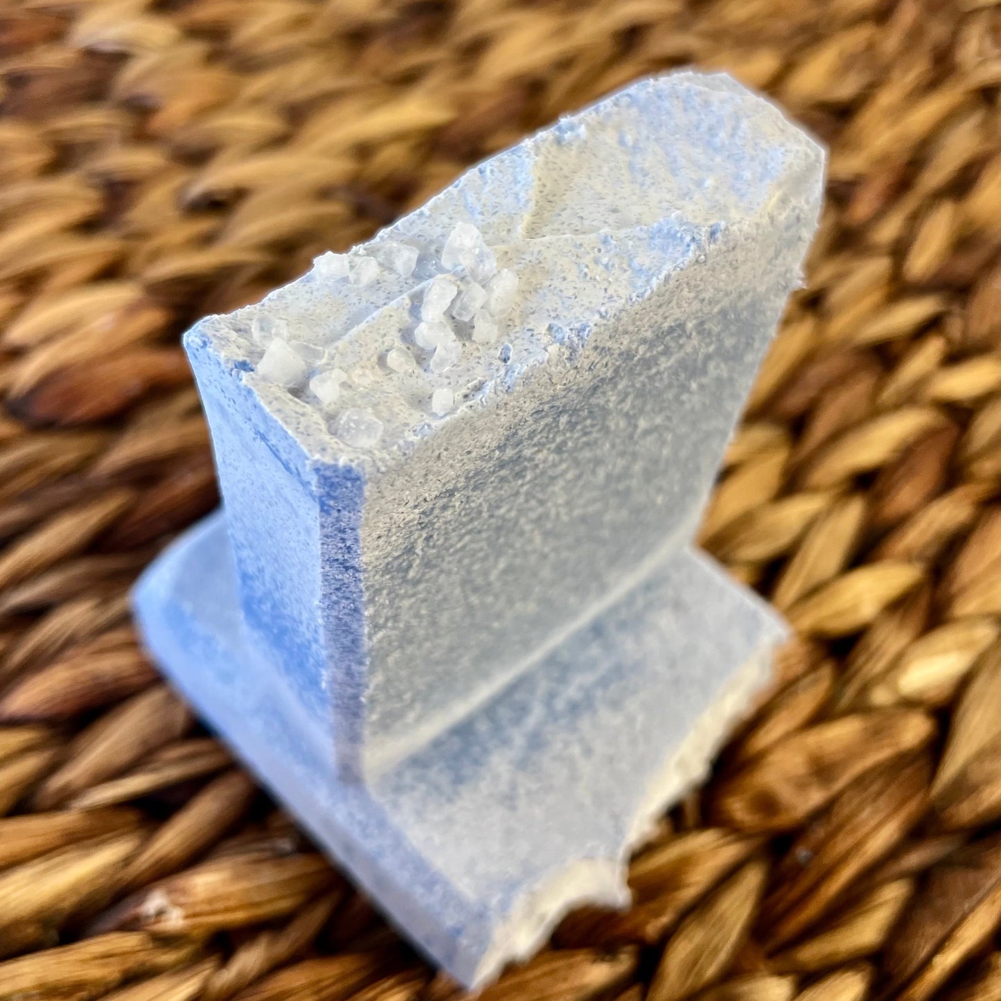 Sea salt bar corner with rough, granular surface and light blue soap body
