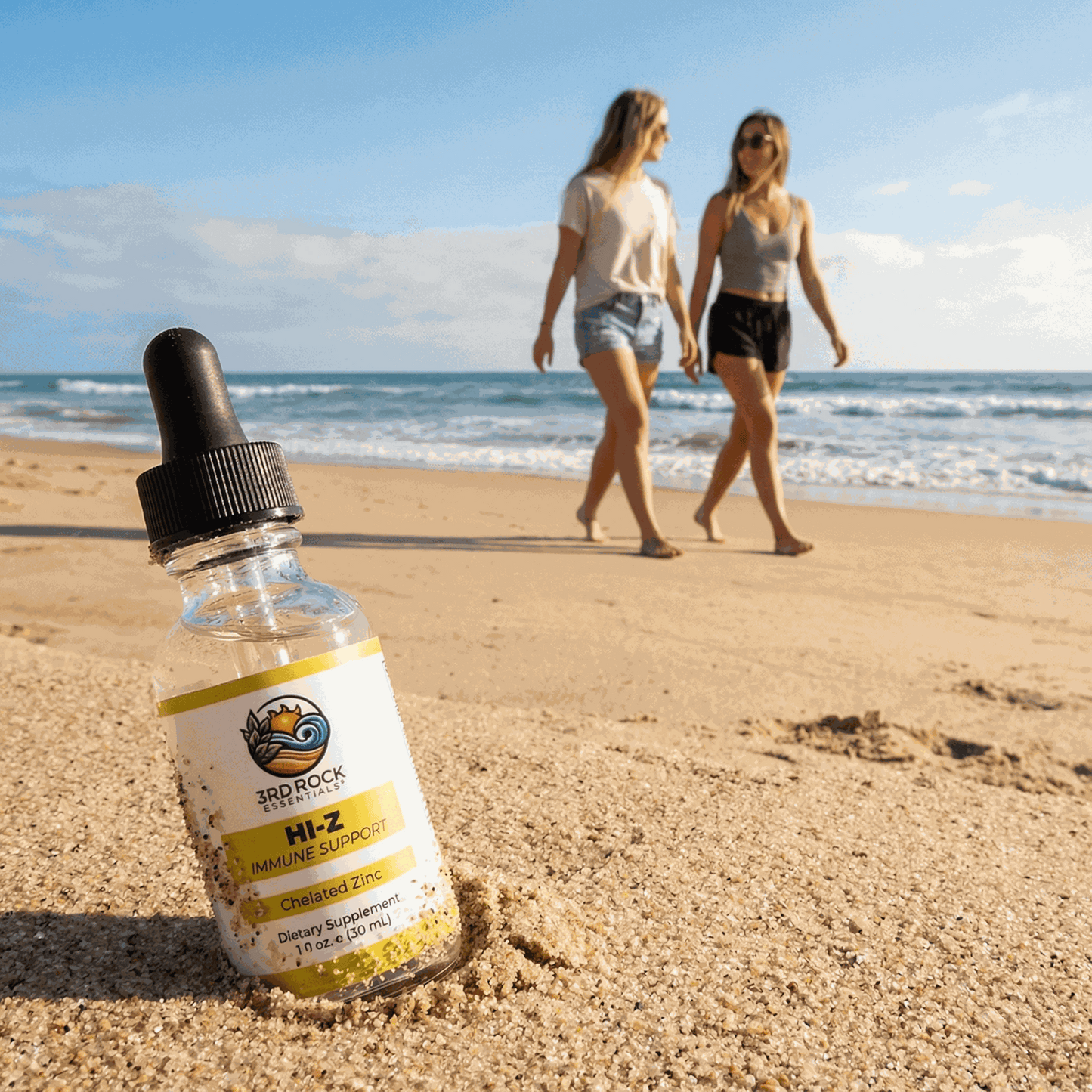 Liquid zinc supplement bottle with black dropper on a sandy beach