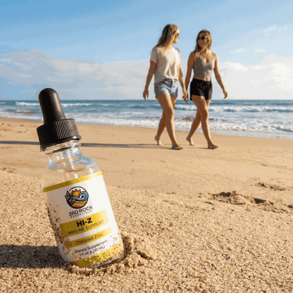 Liquid zinc supplement bottle with black dropper on a sandy beach