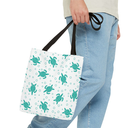 Sea turtle pattern tote bag with teal repeating turtles, held by black carry handles