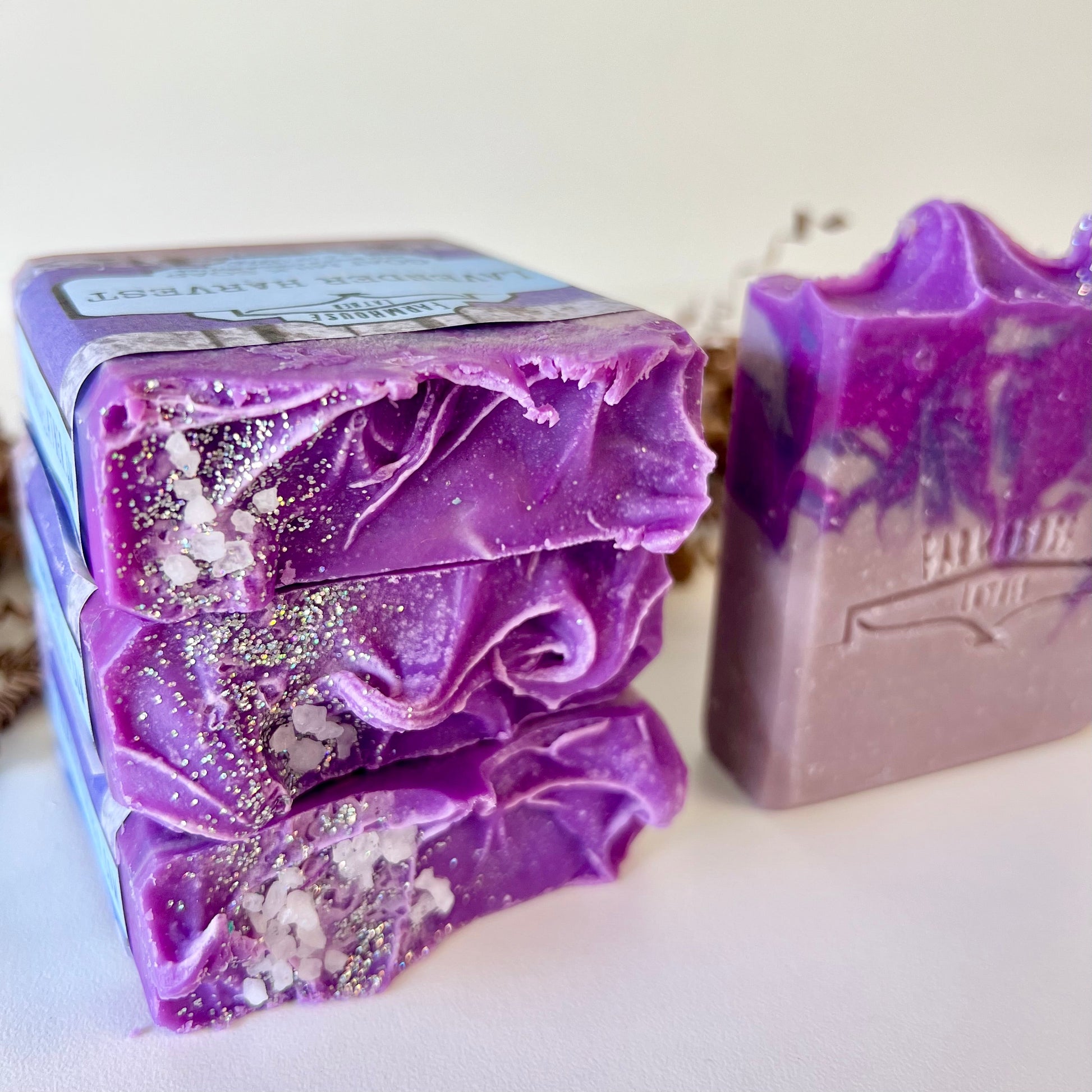 Lavender harvest goat milk soap bar, close-up with purple swirls and glittered flecks