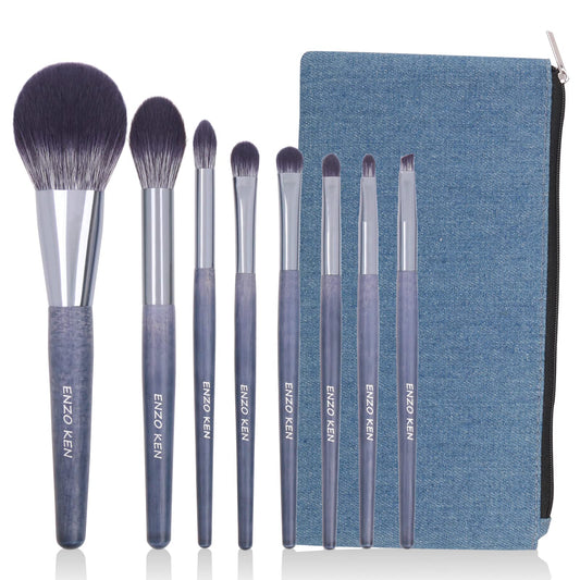 Makeup brush set with eight purple-tipped natural bristle brushes and blue canvas pouch