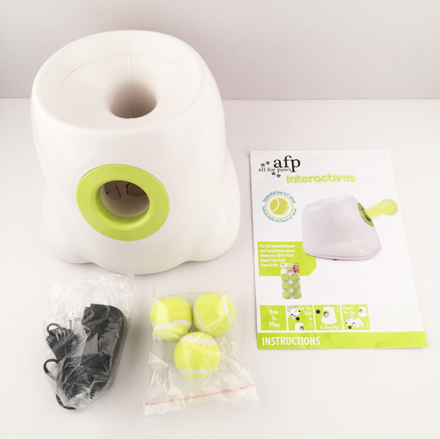 Dog tennis ball launcher kit in white with lime dial, tennis balls, and manual
