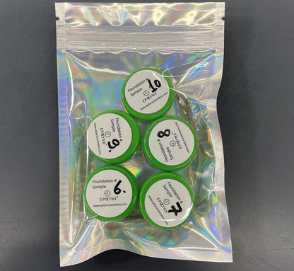 Foundation sample set with five circular lids in a green holographic pouch.