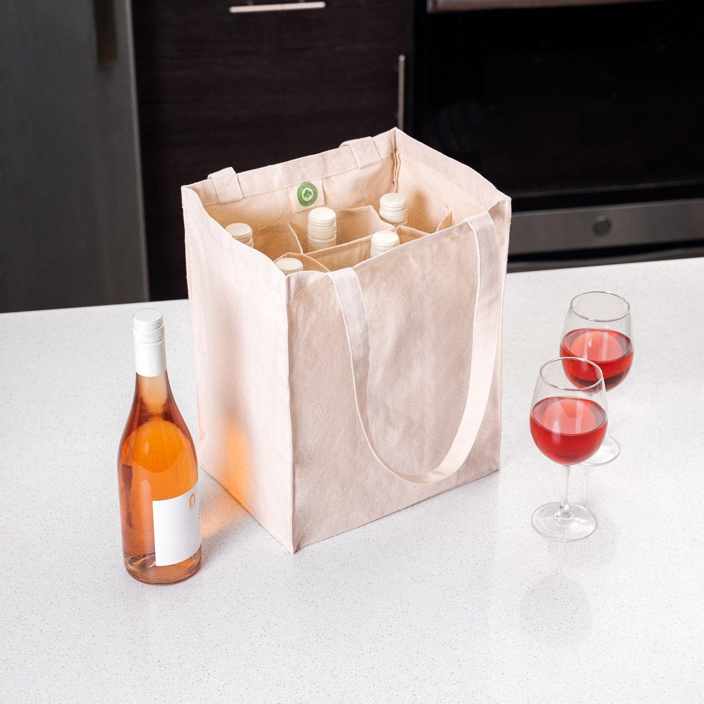 Canvas wine tote bag with loop handles, standing with bottles and wine glasses.