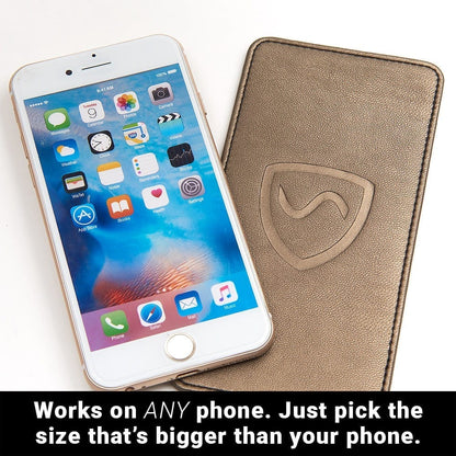 Beige phone shield wallet with stitched border and shielding emblem beside phone