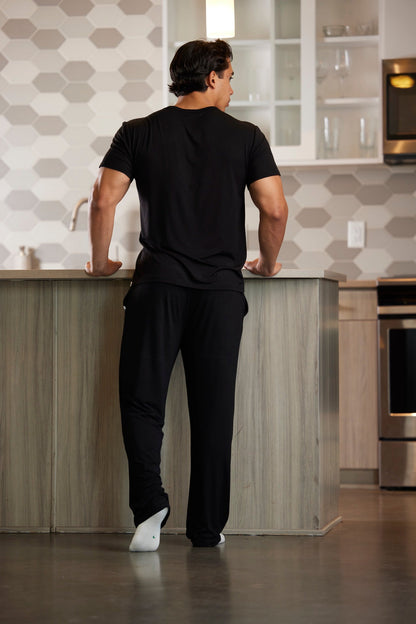 Men's lounge pajama set in black, short-sleeve top and pants shown from back