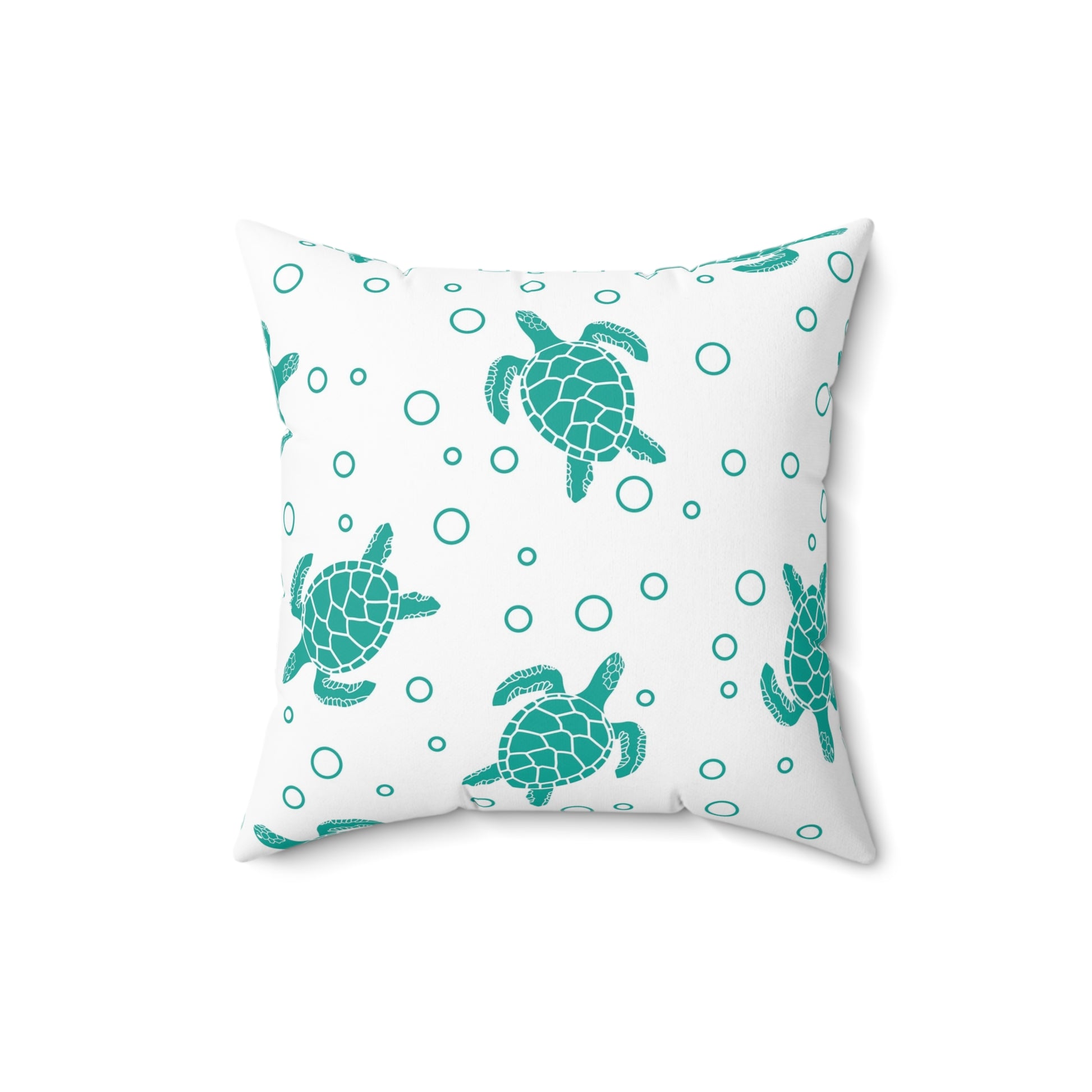 Square decorative pillow with teal sea turtle pattern and teal ring dots on white fabric
