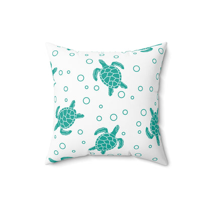Square decorative pillow with teal sea turtle pattern and teal ring dots on white fabric