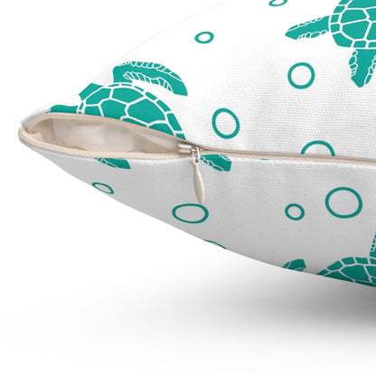 Side view of square pillow: white cover with teal sea turtles, rings, and zipper seam