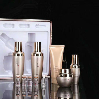 Moisturizing skincare set in tray with gold-capped bottles and small vials