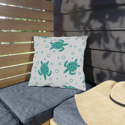 Square outdoor cushion pillow with teal sea turtle print and ring dots on white fabric.