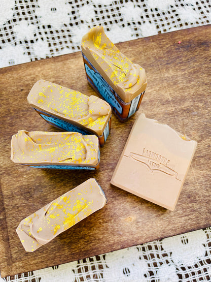 Pumpkin butter soap bars with blue edges and yellow speckle, plus beige box