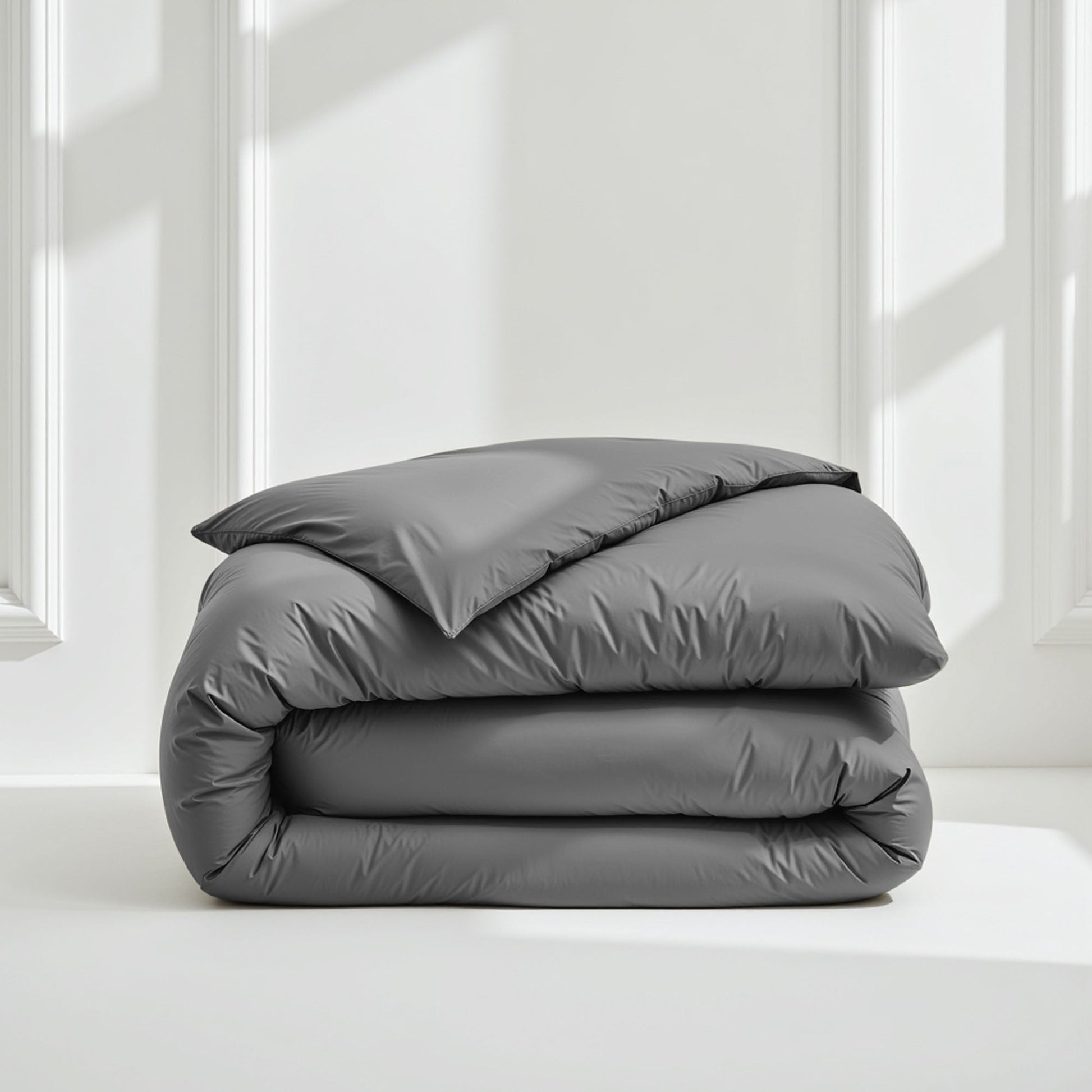 Sateen bedding bundle folded stack with gray duvet and pillows, neatly layered