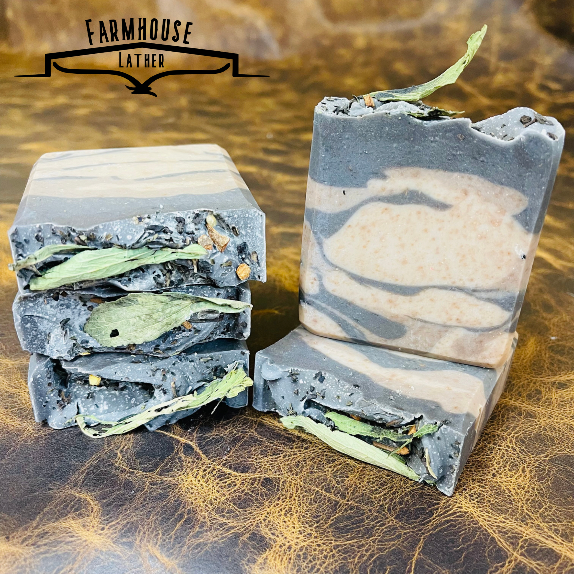 Set of striped bar soaps with blue and cream layers and green herb leaves on top