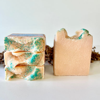 Sea salt soap bars with teal speckled swirls, stacked and one bar shown