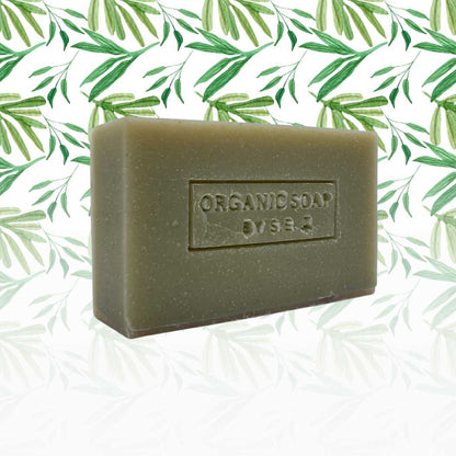Organic bar soap, olive green bar with embossed label and speckled texture.