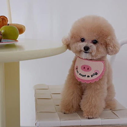 Pink crocheted pet saliva towel with pig face worn by small dog