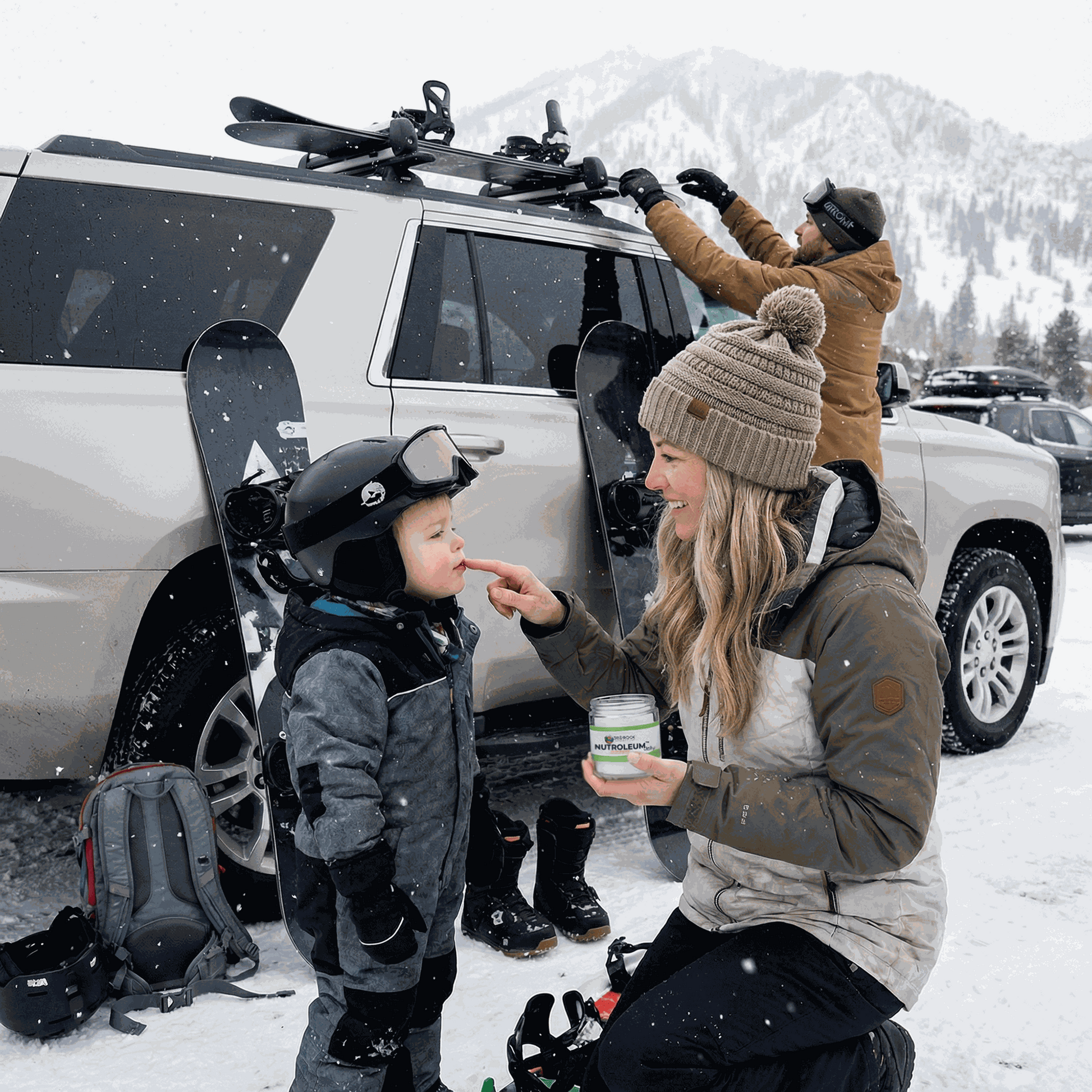 Skin balm jar held during snowy outdoor outing with bundled family