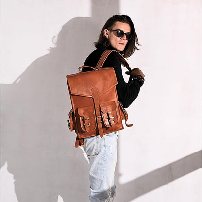 Brown leather backpack with flap and side buckles, worn on shoulder straps.