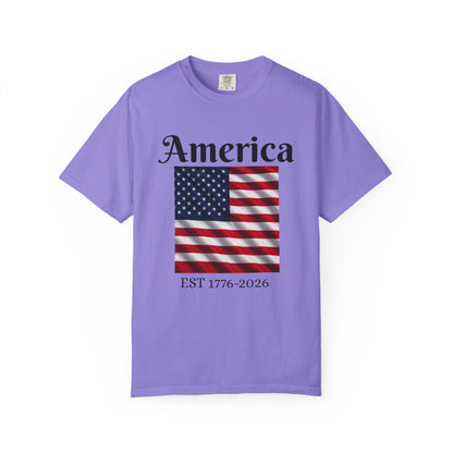 Lavender crewneck T-shirt with "America" text, American flag, and EST 1776-2026