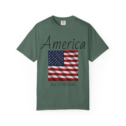 Green unisex t-shirt with “America” script, US flag graphic, and “Est 1776-2026”