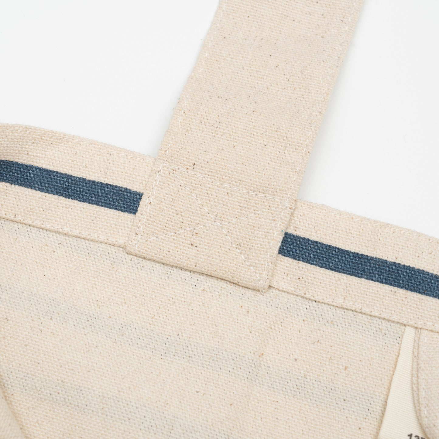 Canvas grocery tote bag detail, blue stripe band across front with stitched seams
