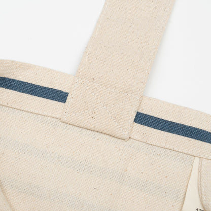 Canvas grocery tote bag detail, blue stripe band across front with stitched seams