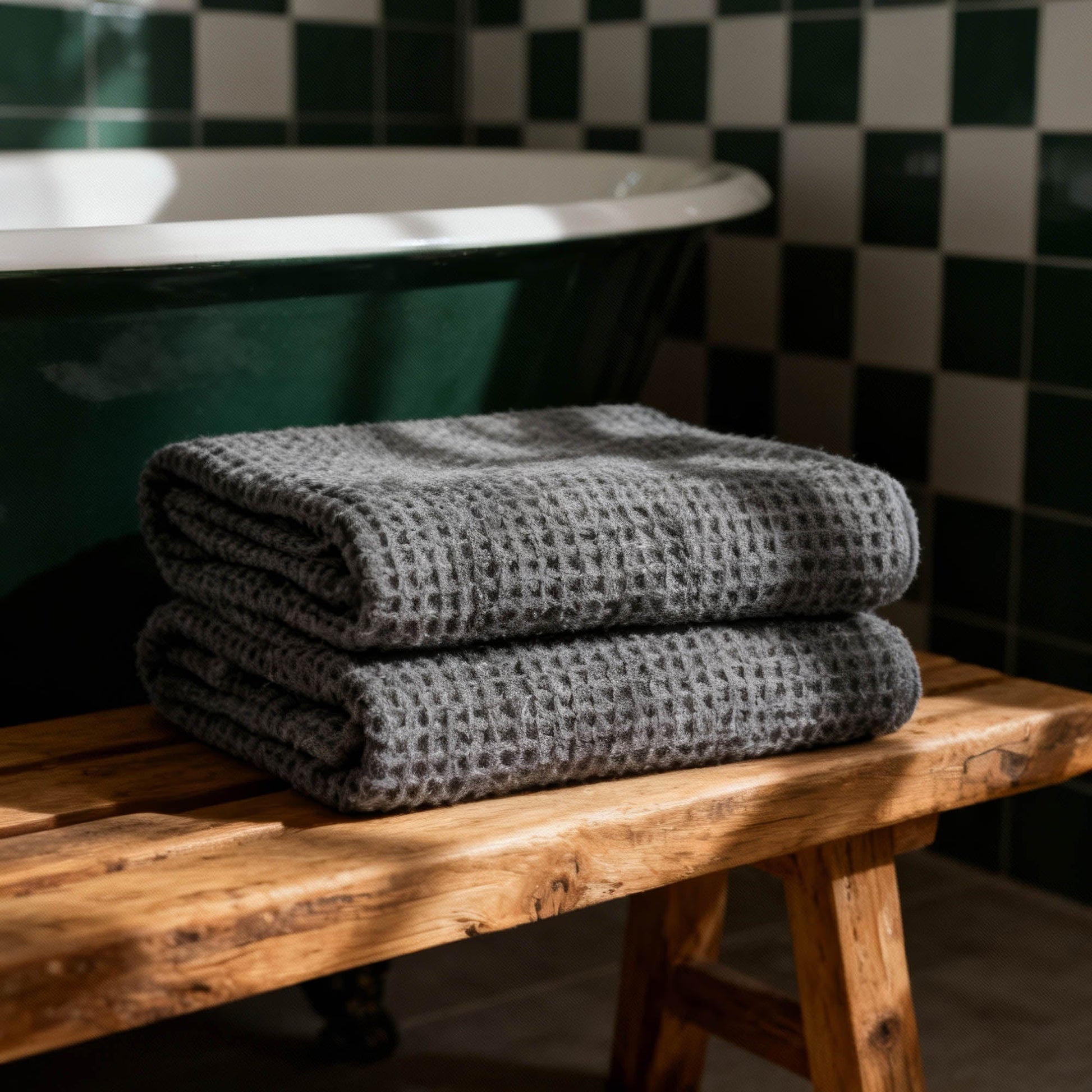Australian cotton waffle towels in charcoal, folded pair on a wooden surface