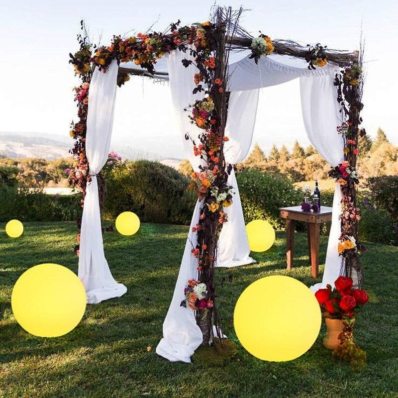 Outdoor LED garden ball lights with large yellow glowing spheres in a garden arch