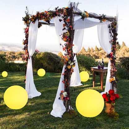 Outdoor LED garden ball lights with large yellow glowing spheres in a garden arch