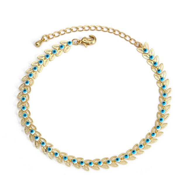 Gold charm bracelet with blue evil-eye leaf charms along the chain and clasp
