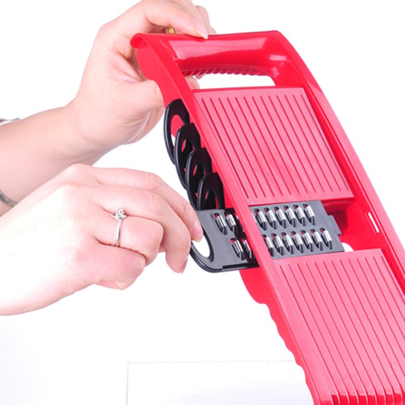 Red handheld vegetable slicer with adjustable blade inserts and multi-size cutting guide.