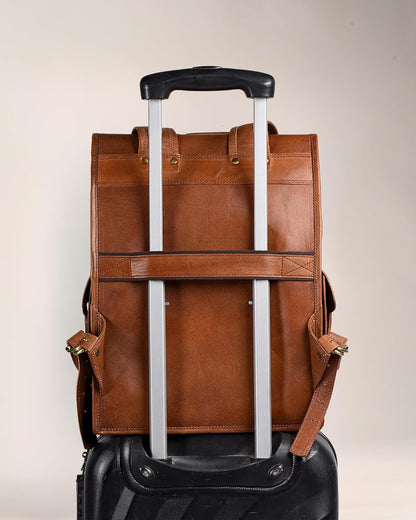 Brown leather backpack with black trolley sleeve and reinforced pick-up handle, rear view.