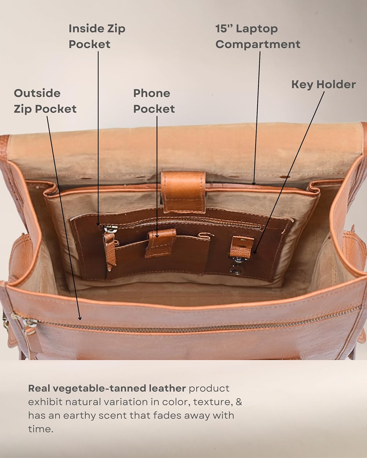 Open brown leather backpack interior with zip pocket and phone pocket.