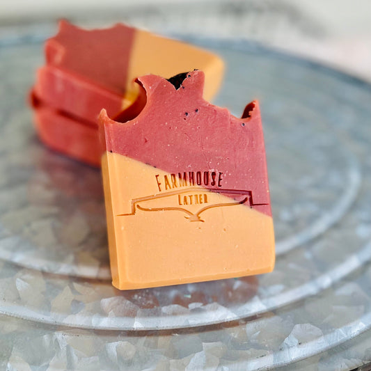 Handmade soap bar, red top and tan base, stamped 'Farmhouse Lather'