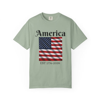 Light green T-shirt with “America” over US flag and “EST 1776-2026” graphic on front