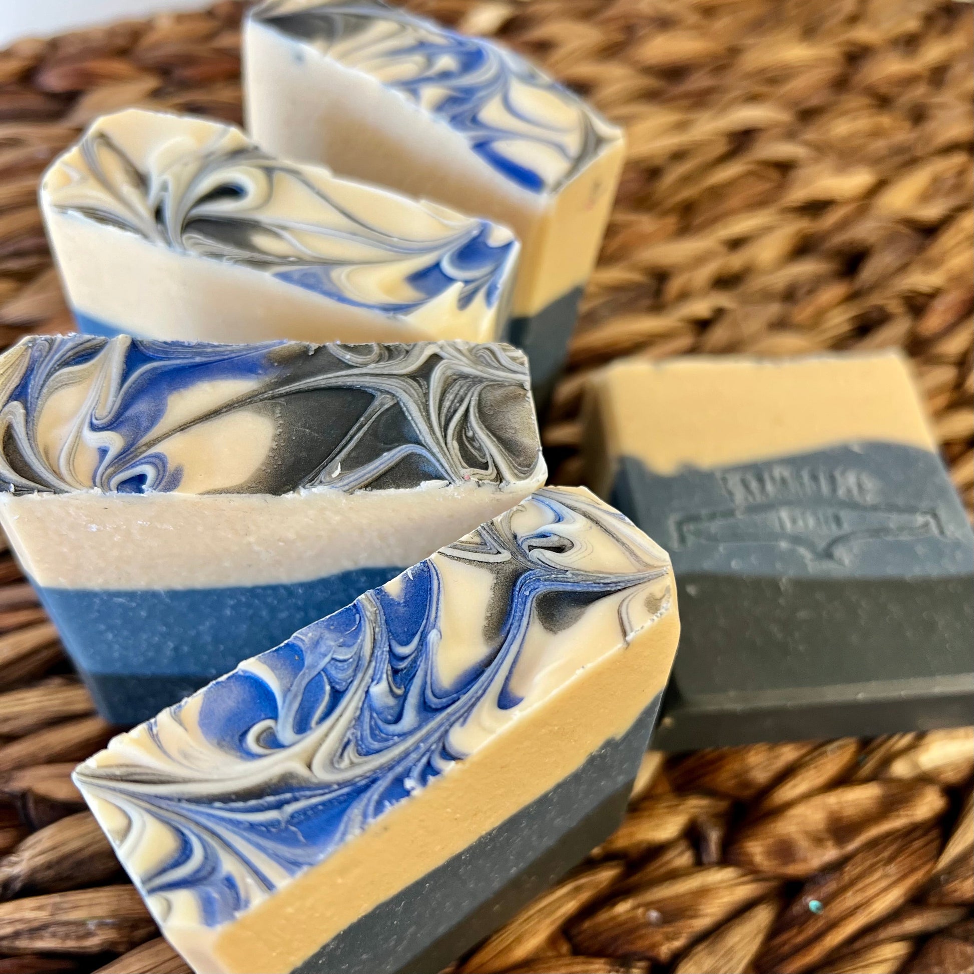 Close-up of blue-and-cream swirled soap bars with stamped label on one bar