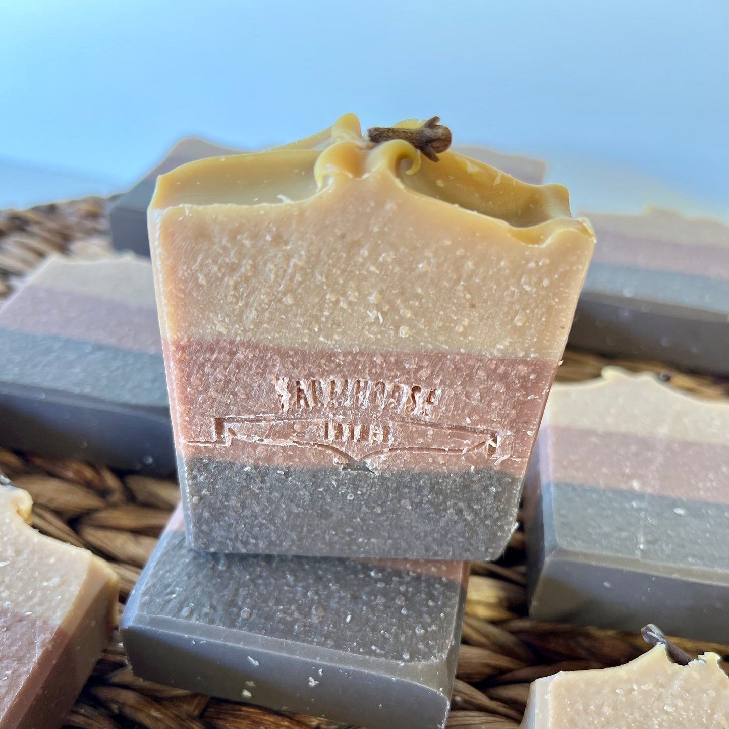 Bourbon Barrel soap bar, golden top and gray-blue base, stamped center logo