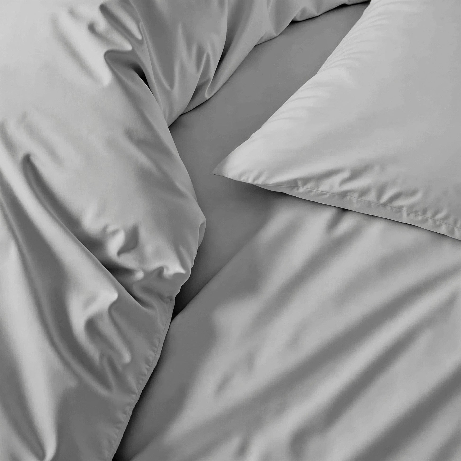 Sateen bedding bundle close-up of gray duvet folds and smooth fabric texture