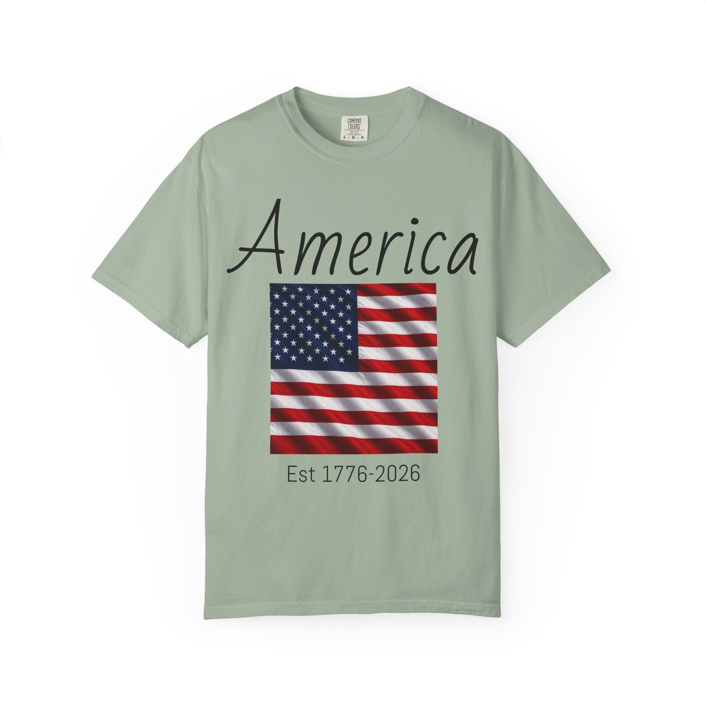 Light green unisex t-shirt with “America” script, US flag graphic, and “Est 1776-2026”