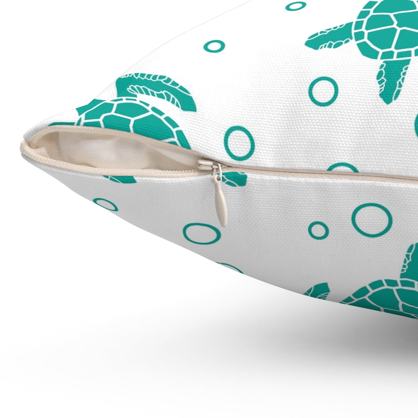 Square decorative pillow corner with zipper closure; teal turtle print on white cover