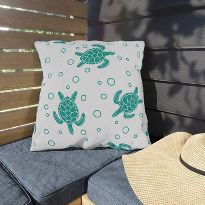Outdoor sea turtle pillow on patio seat, white with teal turtles and circle pattern