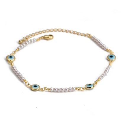 Charm bracelet with gold chain, white beads, and blue evil-eye charms